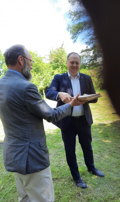 Svečias Audrius Stankevičius sveikina PLC vadovą, vieną iš šventės organizatorių Valdą Kubilių